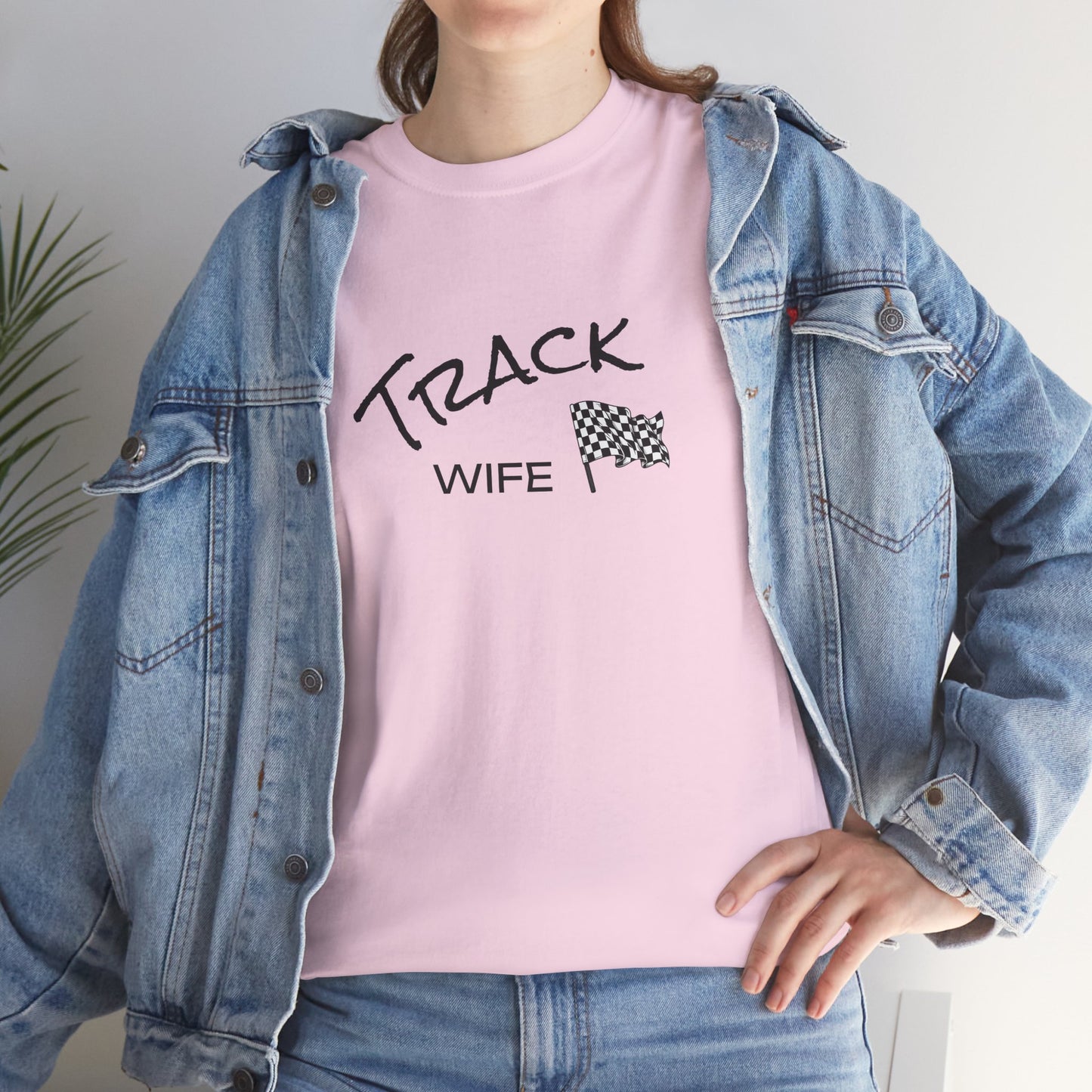 Person wearing a pink t-shirt with 'TRACK WIFE' text and a checkered flag graphic, paired with a denim jacket.