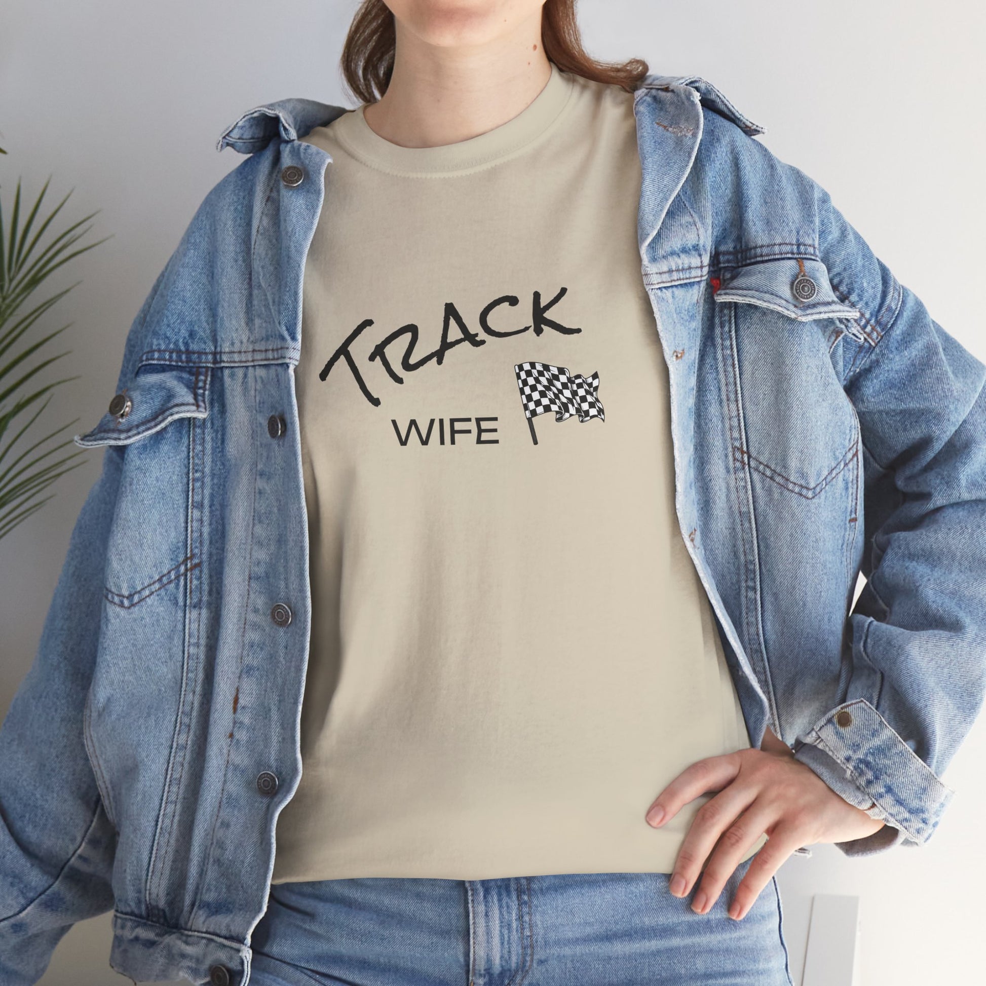 Person wearing a beige t-shirt with 'TRACK WIFE' text and a checkered flag graphic, paired with a denim jacket.