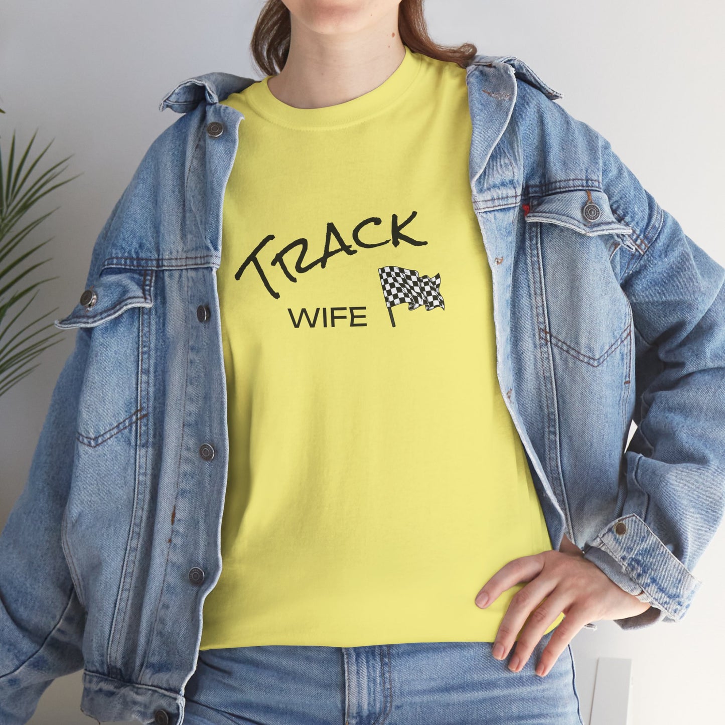 Person wearing a yellow t-shirt with 'TRACK WIFE' text and a checkered flag graphic, paired with a denim jacket.