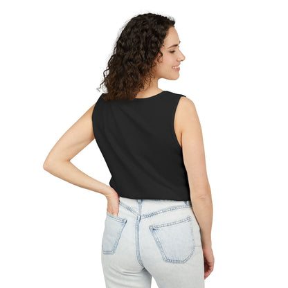 Woman wearing a black sleeveless top and light blue jeans on a white background