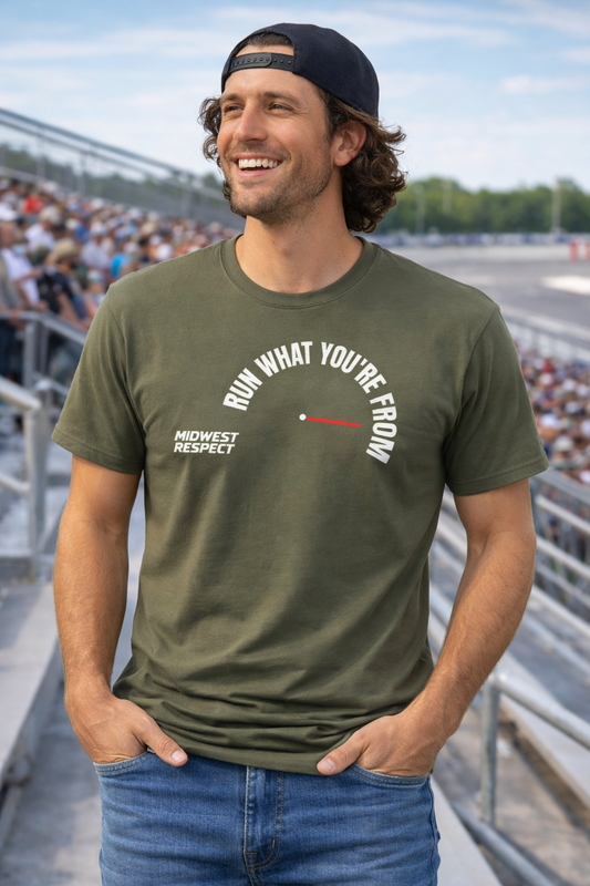 Man wearing a green t-shirt with text at a race track event